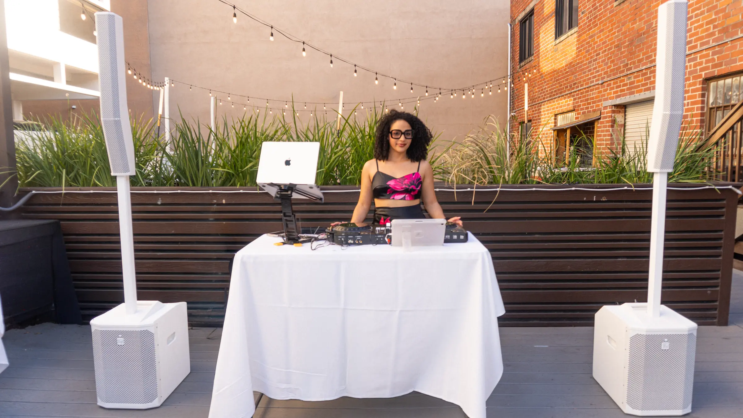 DJ booth with speakers on stands set up outdoors before guests arrive
